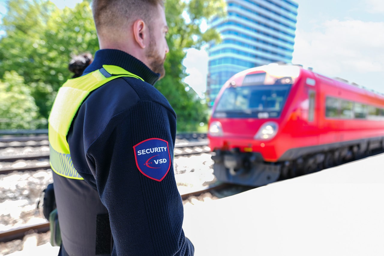 VSD Victory Sicherheitsdienste GmbH – Sicherheitsmitarbeiter im ÖPNV-Sicherheitsdienst an einer Bahnstrecke mit einfahrender S-Bahn