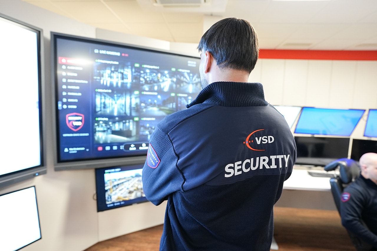 VSD Victory Sicherheitsdienste GmbH – Mitarbeiter der Notruf- und Serviceleitstelle bei der Live-Überwachung von Kamerafeeds auf einem Großbildschirm
